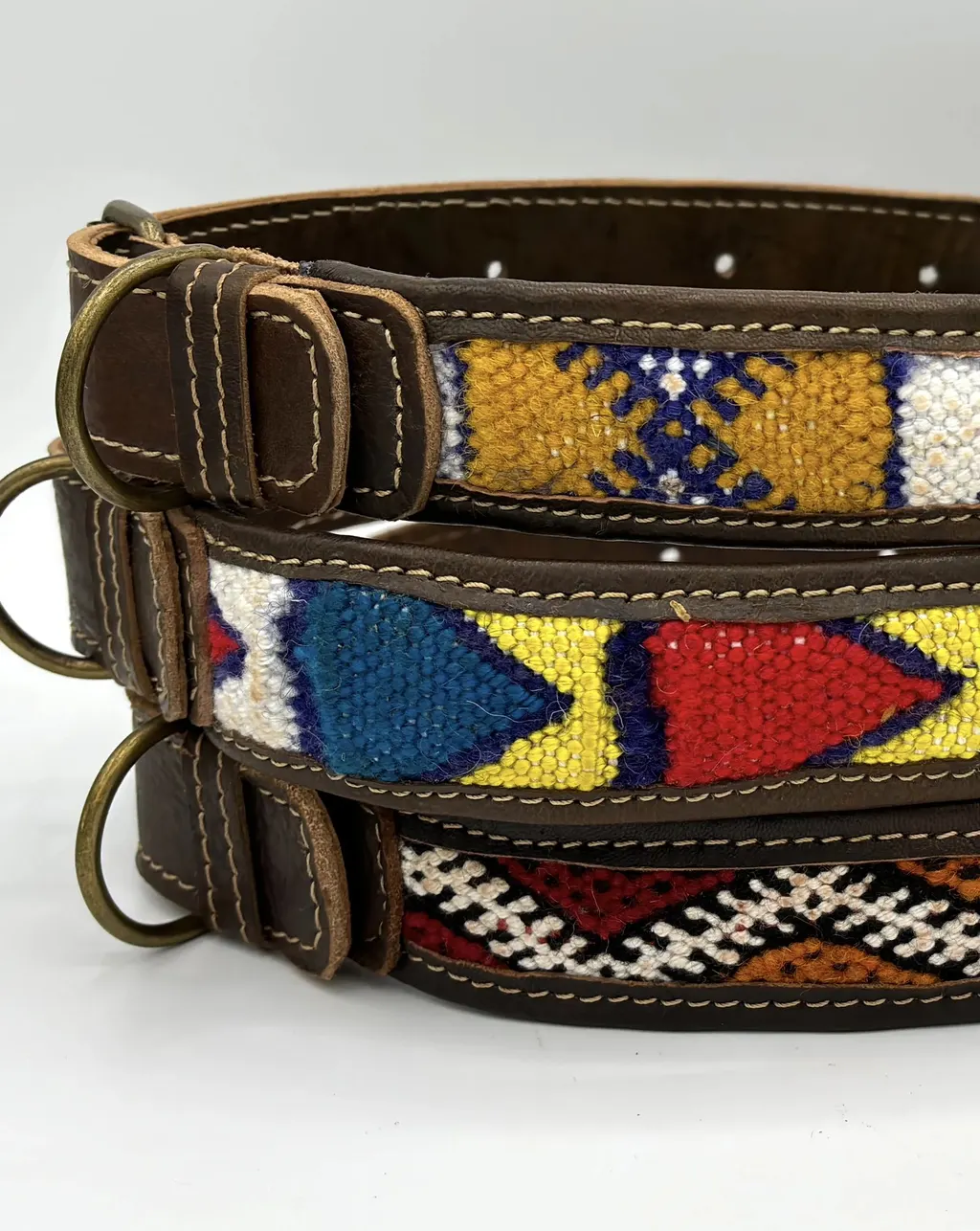 Stacked BohoBarks collars with their brass-tone D-rings and buckles facing out