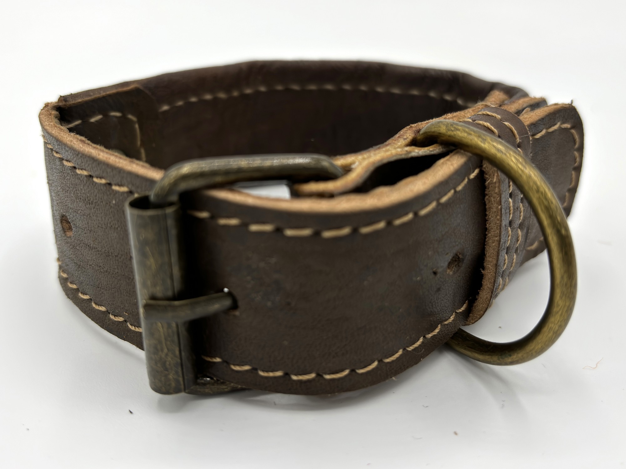The back of a Desert Dunes collar showing the stitched brown leather strap and punched holes